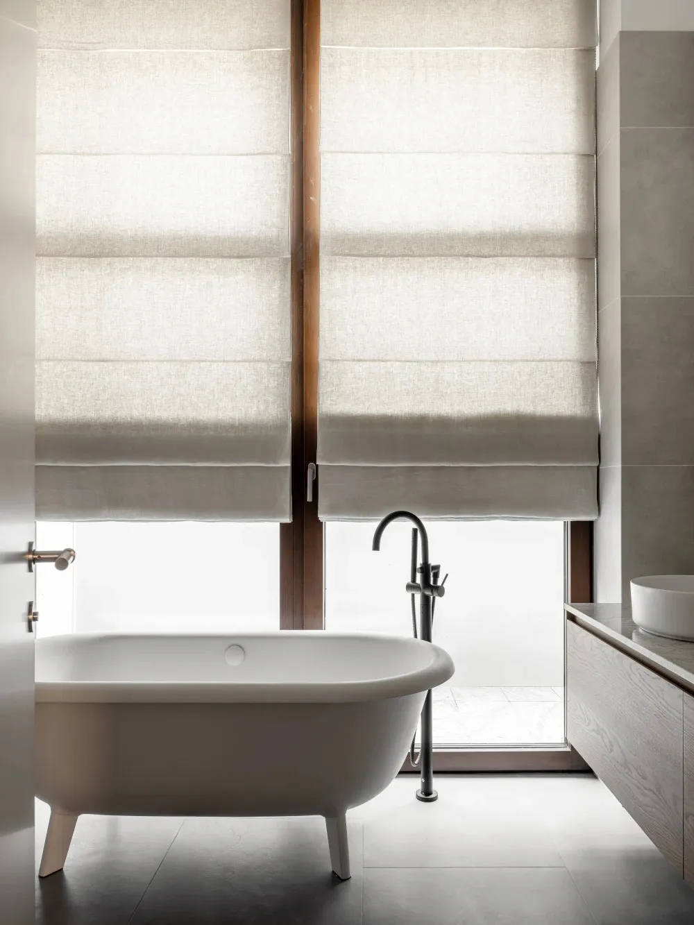 A minimalist bathroom featuring tiled flooring and white fixtures.