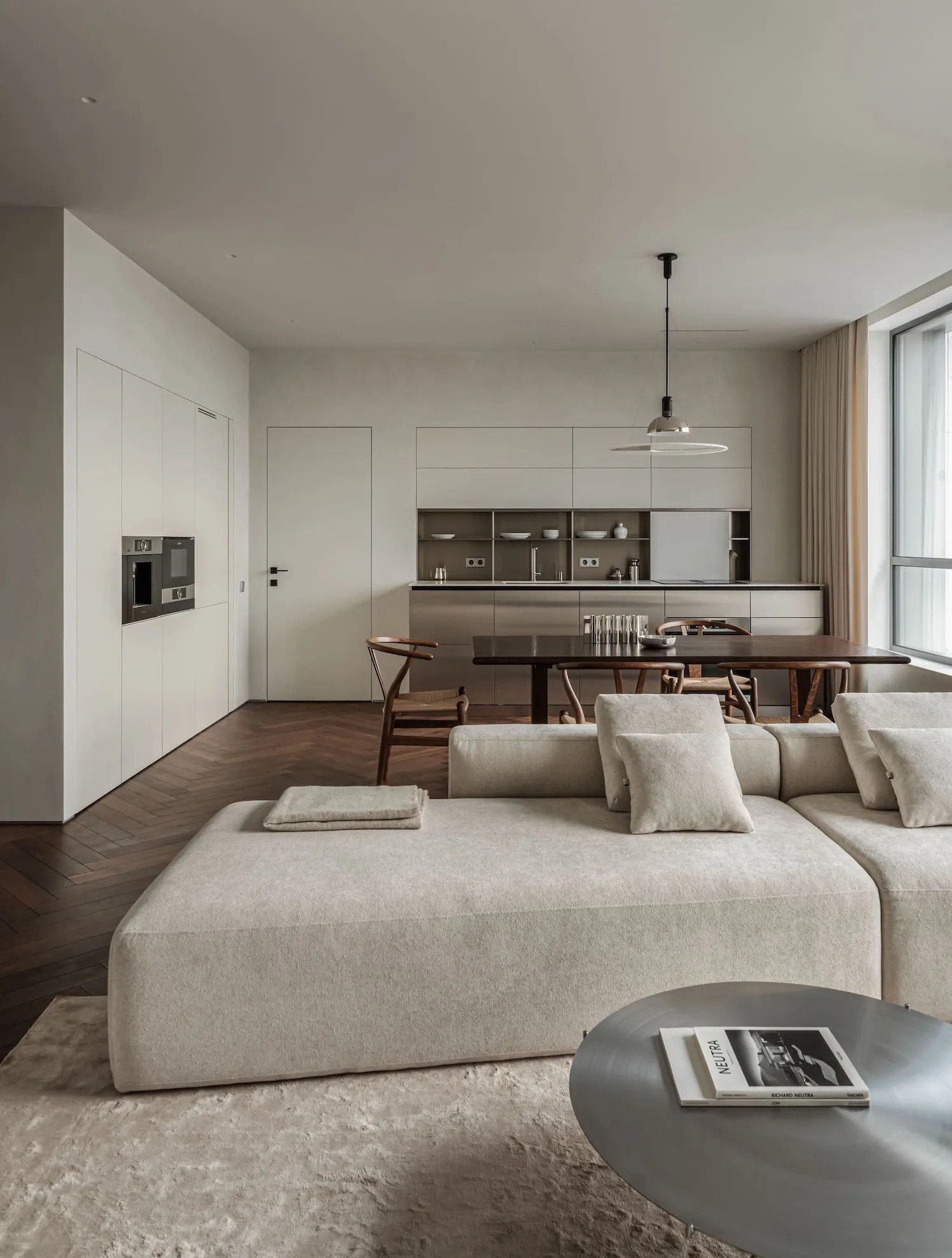 Modern minimalist living room with neutral tones and a large sectional sofa.