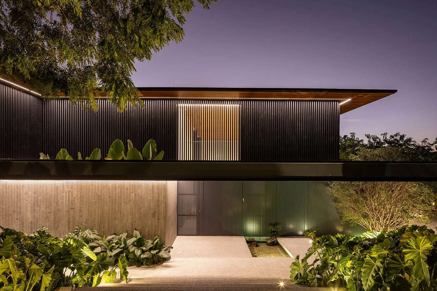 A modern residential building with metal accents and glass panels.