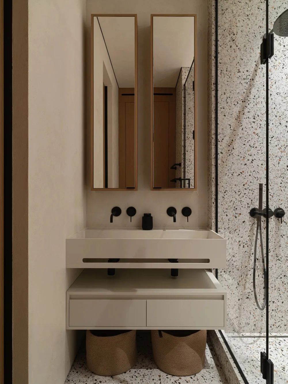 Modern, minimalist bathroom with concrete finishes, floating vanity, and dual mirrors.