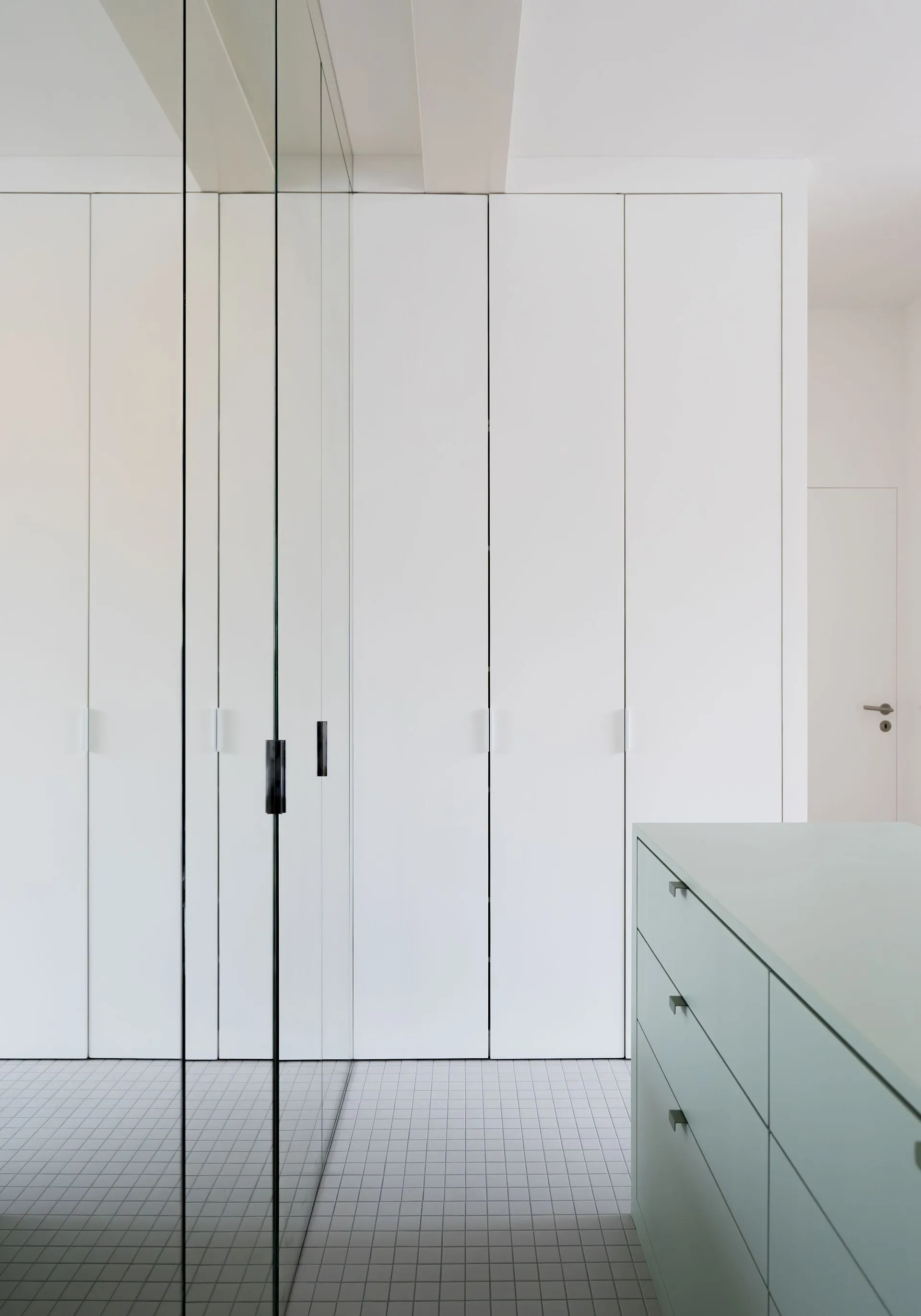 A modern white closet with a minimalist design.