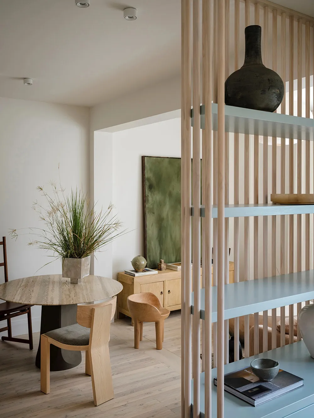 A modern minimalist living room with concrete floor, wooden furniture, and metal elements.