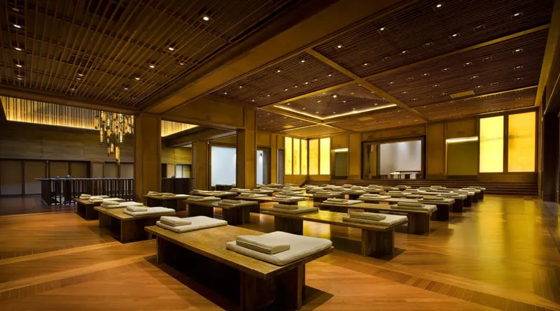 An empty, minimalist conference room with wooden benches and cushions, designed for efficiency and comfort.