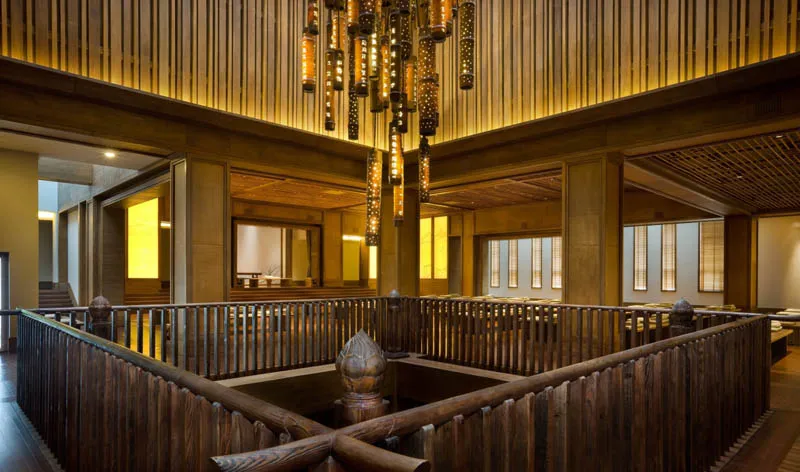 A traditional residential indoor space with a wooden interior and a central wooden railing.