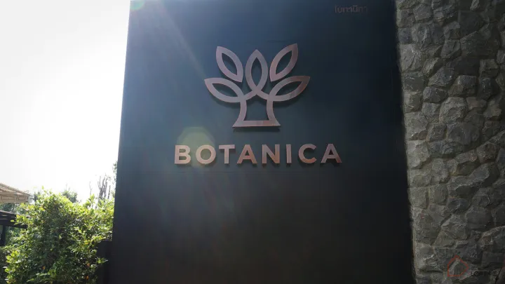 黑色戶外招牌搭配金屬葉片圖騰,顯示「BOTANICA」字樣。