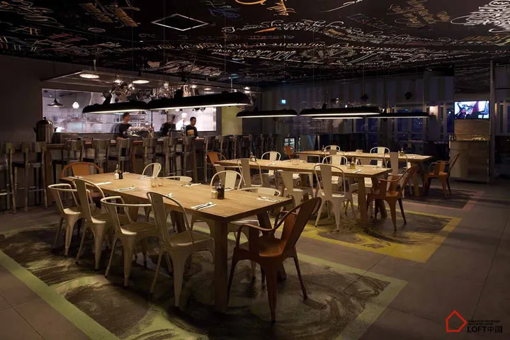 工業風餐廳內擺放木製餐桌,並搭配現代燈具。