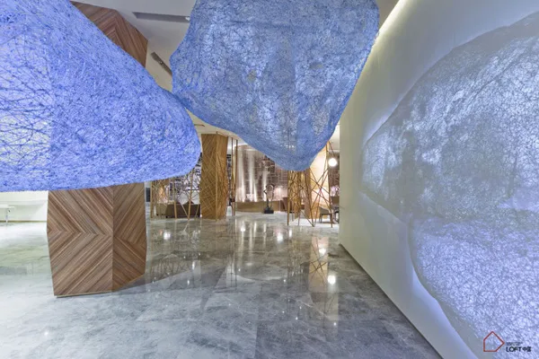 A modern luxury lobby featuring textured glass panels and fiber installations.