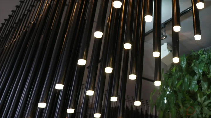 Modern industrial interior featuring exposed metal pipes and illuminated lighting fixtures.