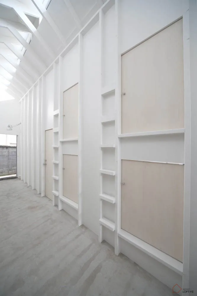 A minimalist bedroom with a concrete floor and walls.
