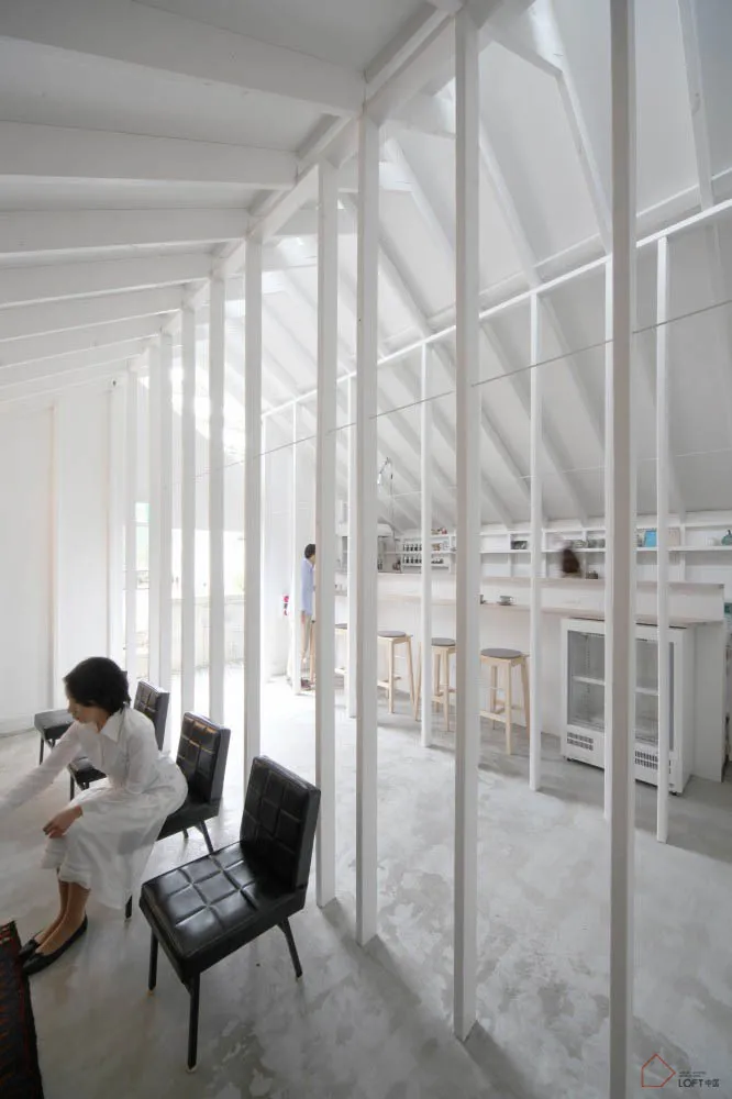 極簡白色空間的室內,搭配混凝土地板與家具。