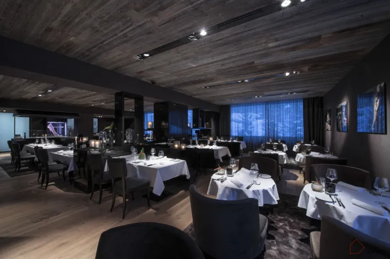 A luxurious modern dining room featuring metallic and wooden elements.