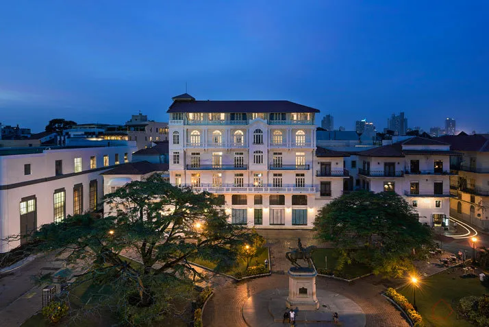 一座白色建築物,陽台燈光亮起,中央有庭院