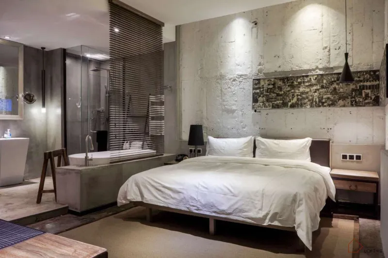 Modern industrial-style bedroom with concrete walls and minimalist furniture.