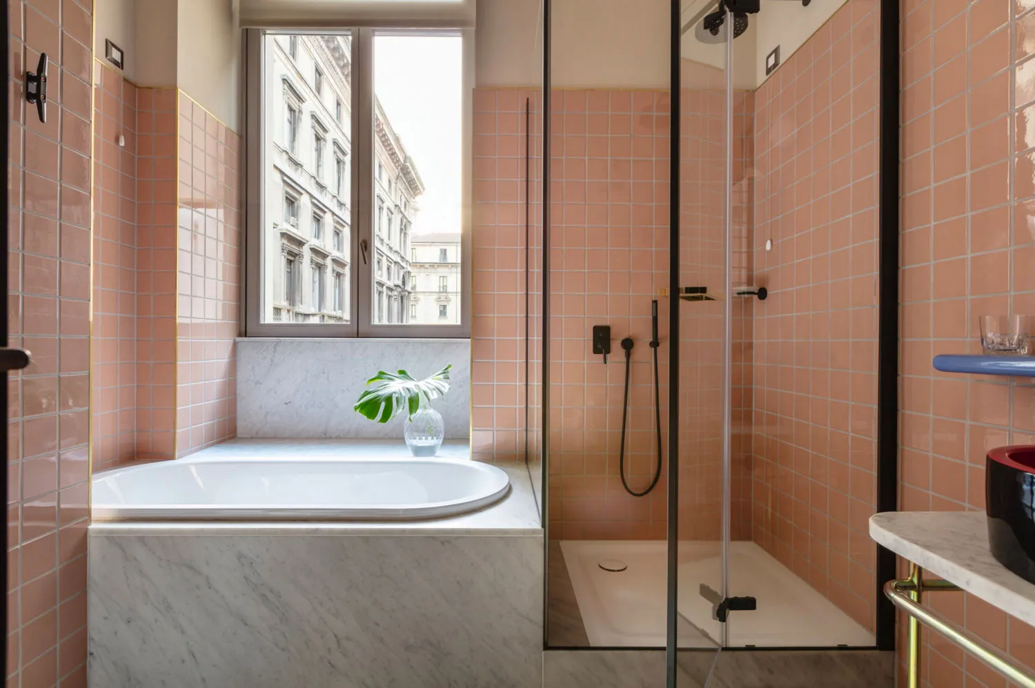 Modern bathroom with coral-colored ceramic tiles and a white marble countertop.