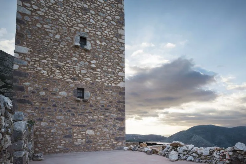 A stone tower building with a cloudy sky in the background.