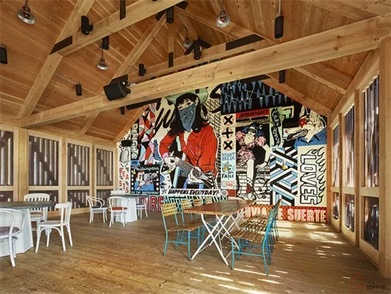 都市風格咖啡廳室內,木質地板、白椅與牆面彩色藝術作品。