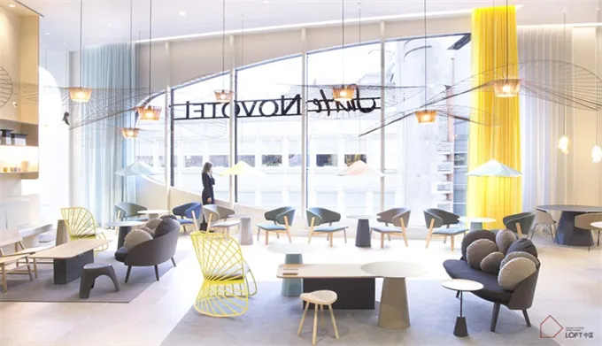 Modern cafe space featuring minimalist furniture and bright yellow accents.