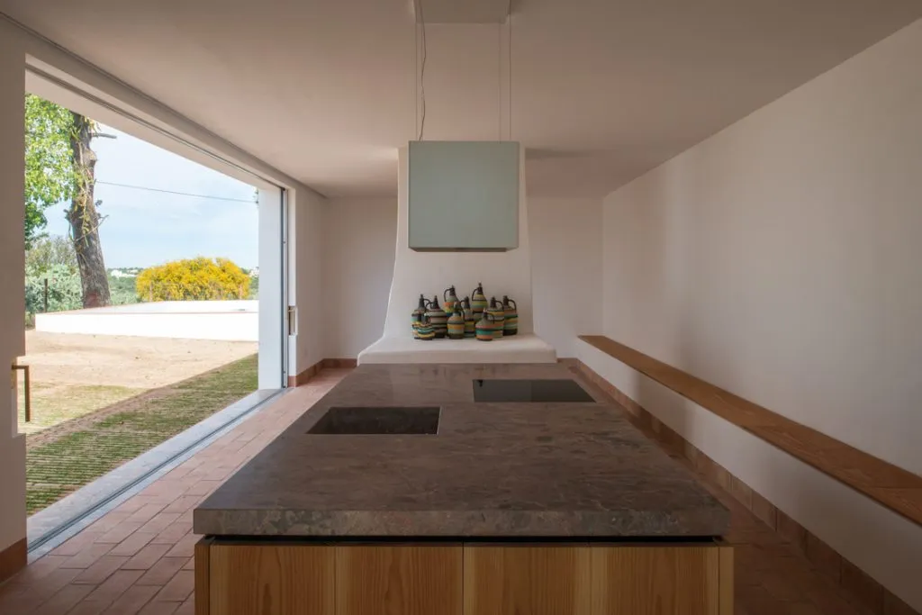 A modern kitchen with a marble countertop and a view of the outdoors.