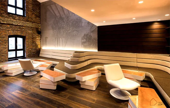 Modern office reception desk featuring comfortable seating and soft furnishings.