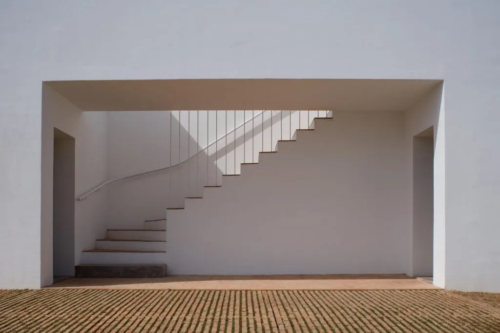 Modern white concrete staircase with white railings.