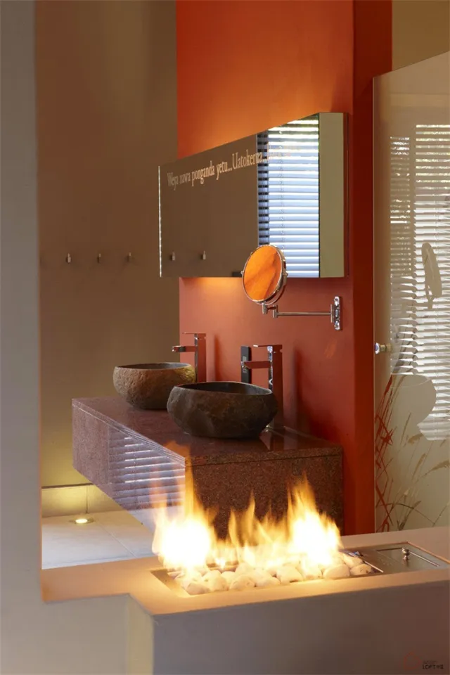 A minimalist bathroom featuring a granite countertop with two sinks and a fireplace.