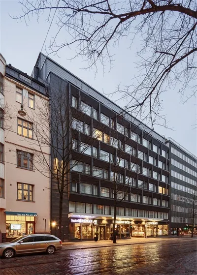 Modern apartment building with glass and metal exterior, viewed from the street