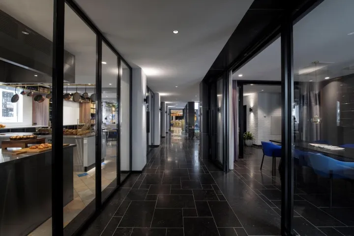A modern restaurant corridor featuring glass walls.