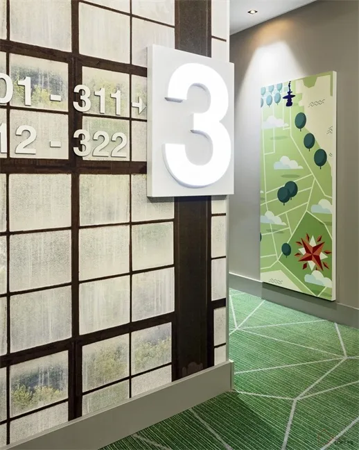 A hallway with a wallpapered wall featuring numbers and a map.