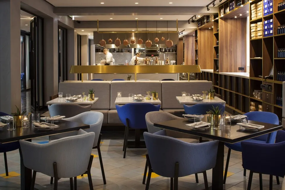 A modern restaurant interior with neutral tones and contemporary furniture.