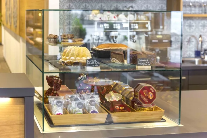 玻璃展示櫃內擺滿各種麵包與甜點的麵包店零售空間。
