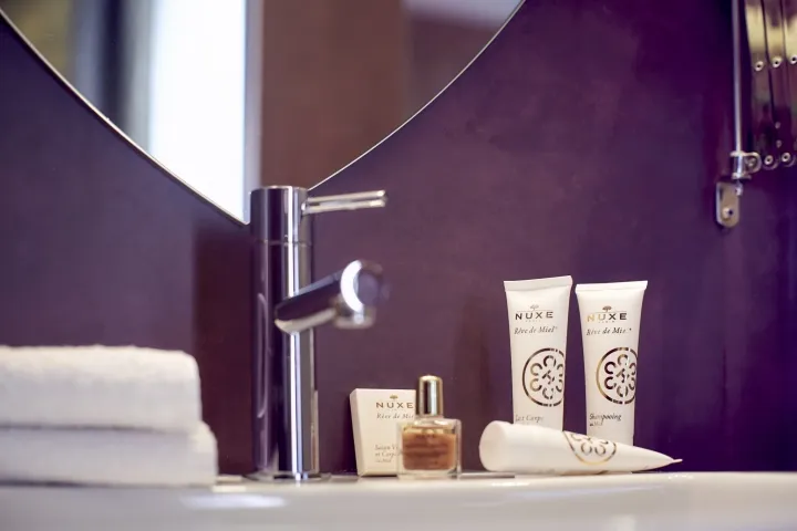 A minimalist bathroom scene featuring ceramic accessories, including a sink faucet and toiletries.
