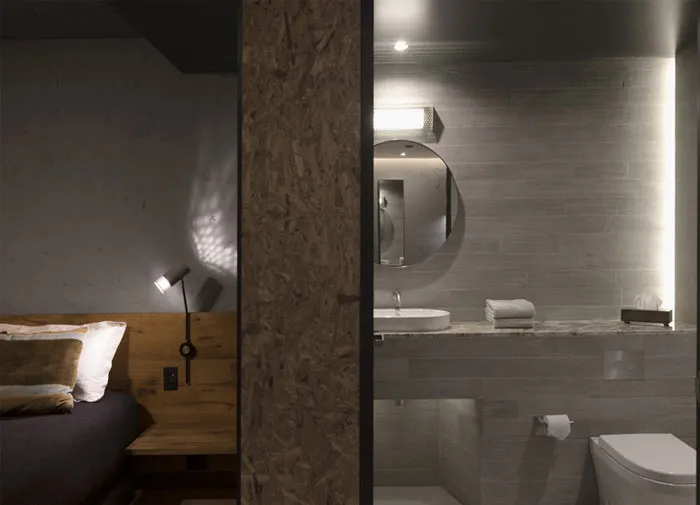A modern minimalist bedroom featuring wood accents and a wooden headboard.