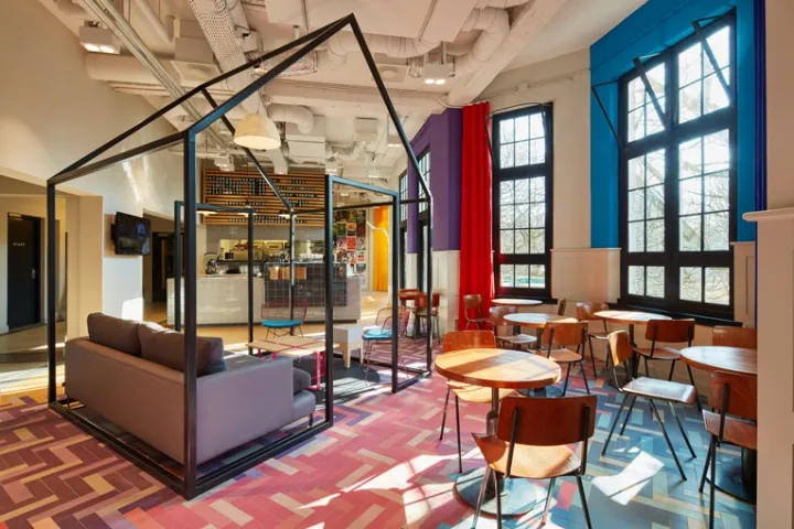 Modern interior design featuring mixed materials with seating and tables in a casual meeting area for coffee shops.