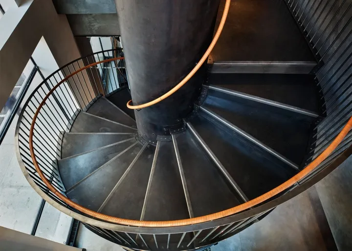 Industrial spiral staircase constructed from metallic and wooden materials