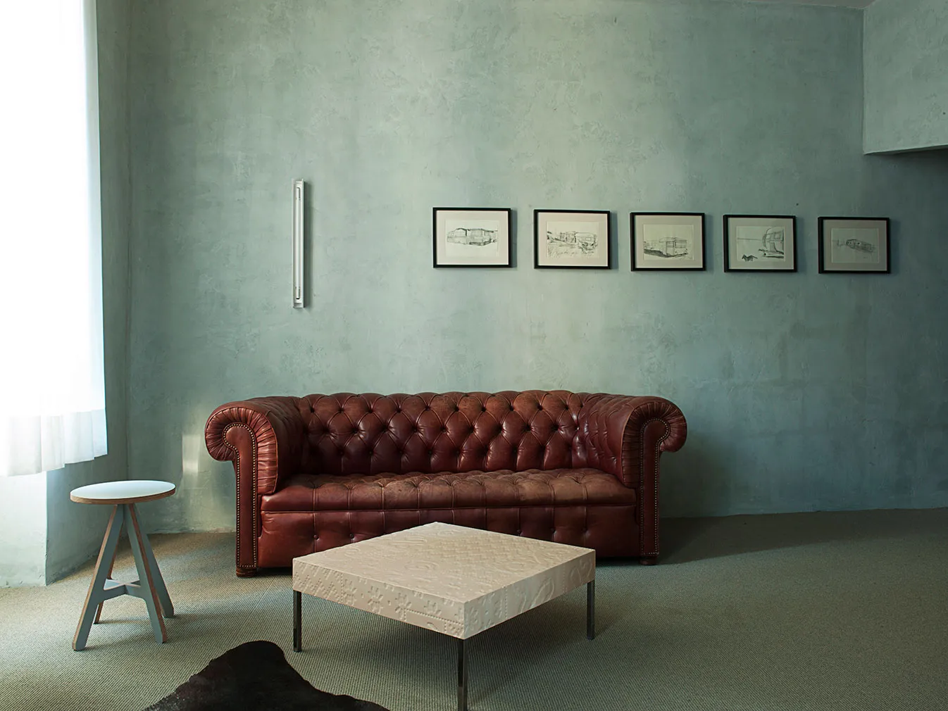 A modern, leather sofa with tufted cushions in a minimalist, industrial-style living room.