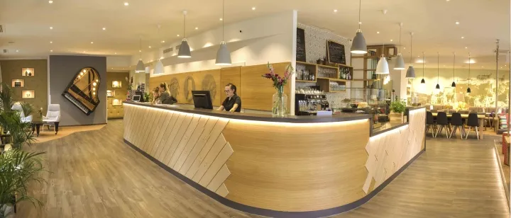 Interior view of a modern coffee shop featuring a wooden counter and seating area.