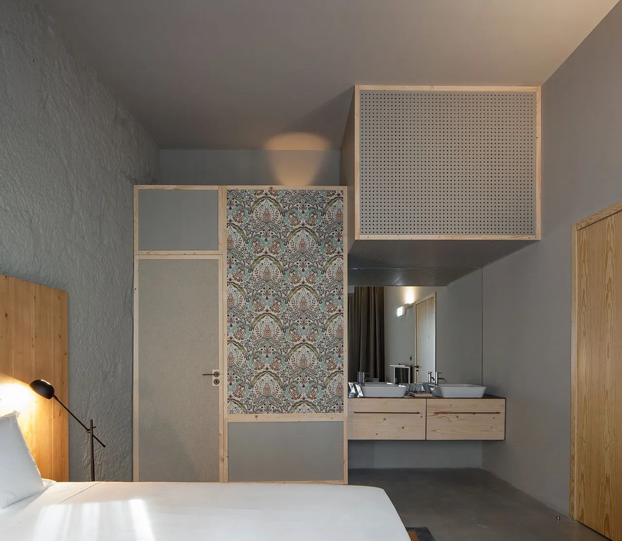 A minimalist bedroom featuring plaster walls and wooden furniture.