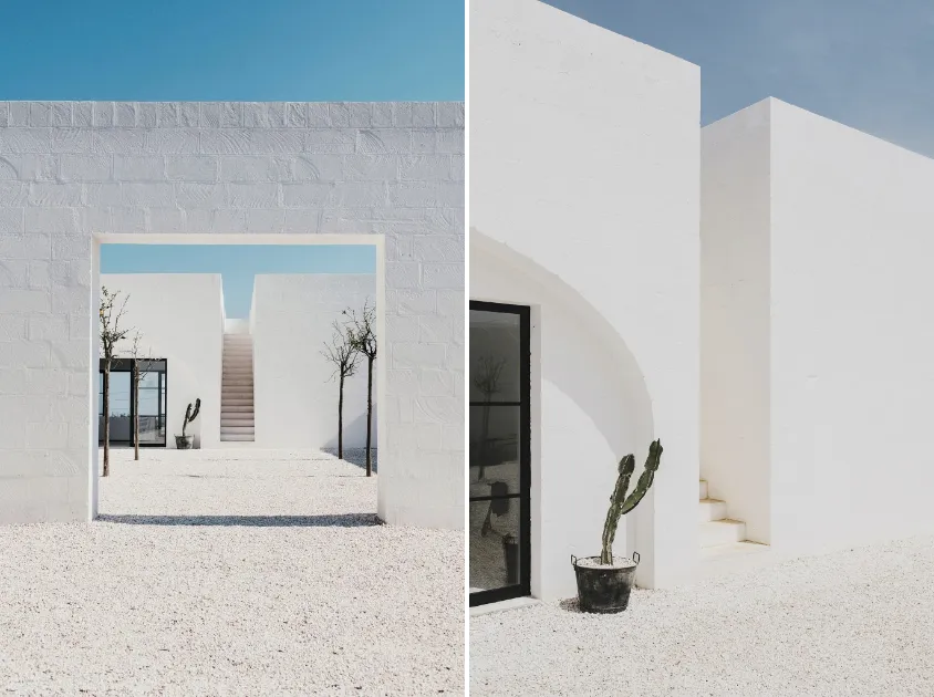 Modern minimalist white plaster exterior with arches and gravel pathway