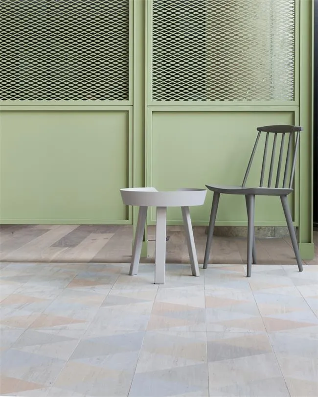 A modern interior design featuring a tiled floor, concrete furniture, and green paneling.