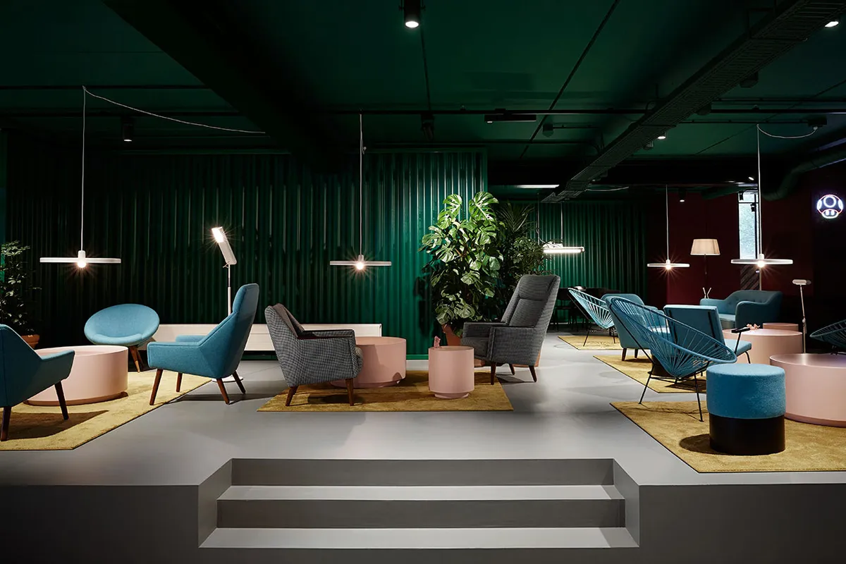 A modern living room with a mix of fabric, metal, wood, and concrete furniture.