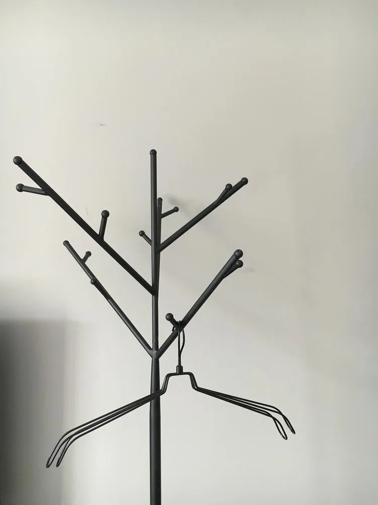 A modern metal tree rack with multiple hooks and hangers.
