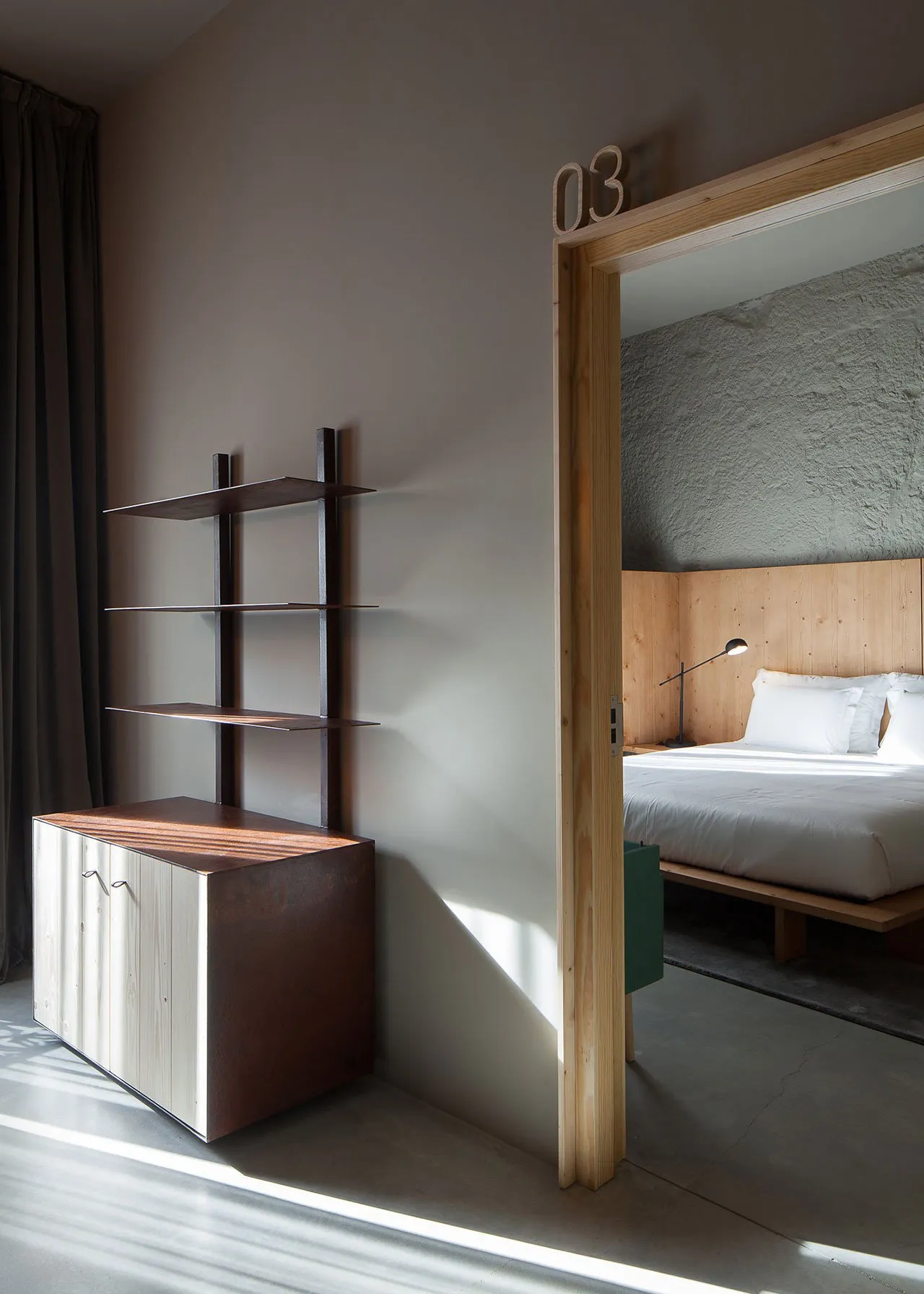 Modern minimalist bedroom featuring a wooden headboard and flooring, with a minimalist design and white bedding.