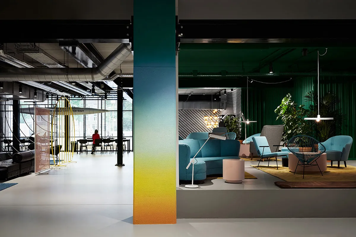 Modern lobby with white floors, blue furniture, and concrete accents.
