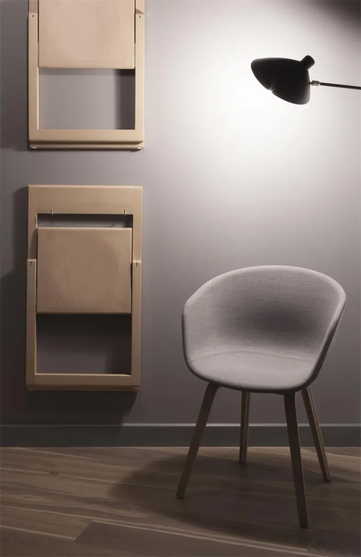 Modern minimalist interior design with a fabric chair and foldable chairs on the wall.