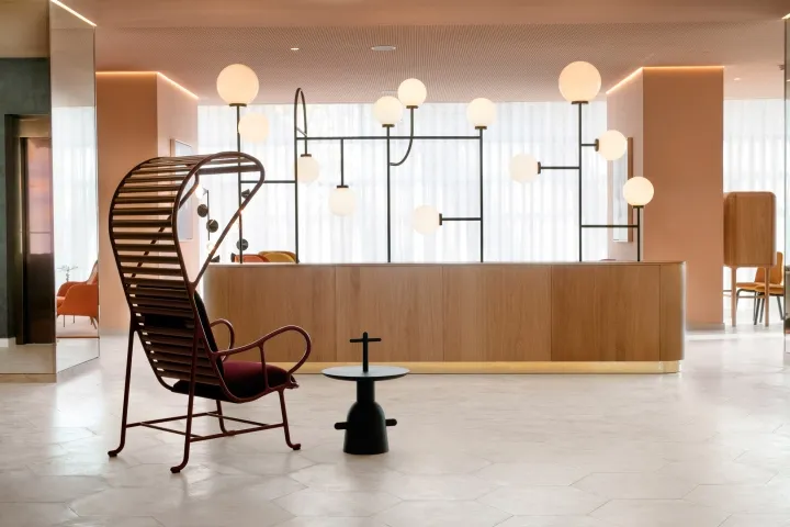 Minimalist reception area with wooden accents and hanging globe lights.