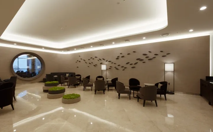 Modern hotel lobby featuring concrete and marble elements.