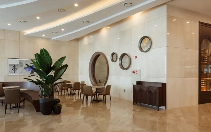 Modern lobby interior with marble flooring, furniture, and decor.