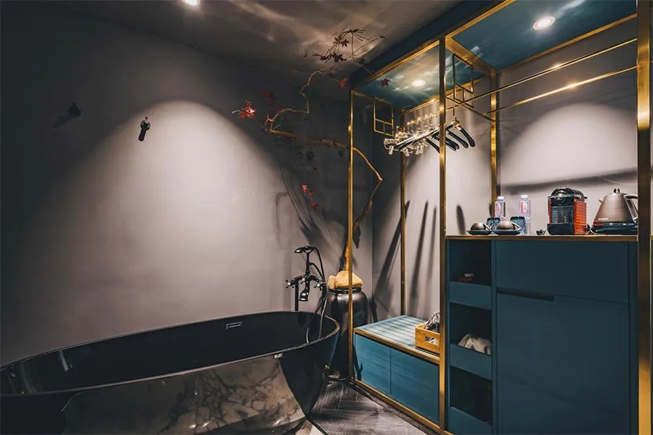 A minimalist bathroom with a marble bathtub, modern fixtures, and sleek, dark furnishings.