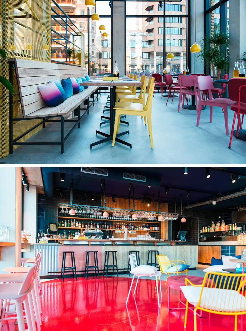 A modern cafe bar with metal painted flooring, fabric seat cushions on wooden furniture, plastic yellow chairs, glass tables,