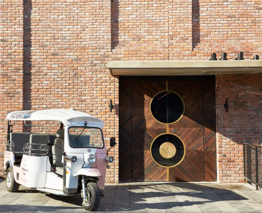 A modern hotel featuring a brick facade and a glass door with decorative elements.